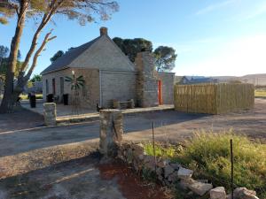 an old stone building with a fence in front of it at Little Artist Cottage in Sutherland