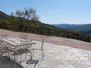 einen Tisch und Stühle auf einer Terrasse mit Bergblick in der Unterkunft Belvilla by OYO Poggio Marino in Carpegna