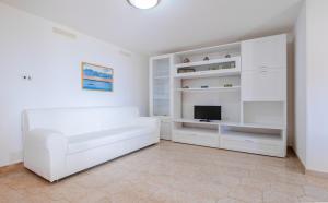 un soggiorno bianco con divano bianco e TV di Villa Euforbia Vista Mare - Pescoluse a Marina di Pescoluse