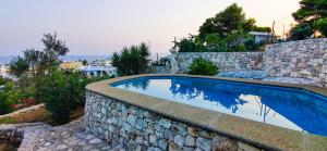 una piscina in un muro di pietra accanto a un muro di pietra di Villa Euforbia Vista Mare - Pescoluse a Marina di Pescoluse