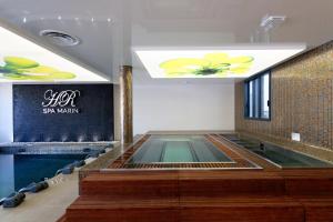 una piscina al centro di un edificio di HR Hôtel & Spa Marin a La Flotte