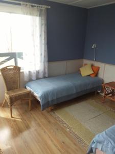 a bedroom with a bed and a chair and a window at Tuule Villa in Kuressaare