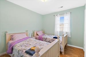 1 Schlafzimmer mit 2 Betten und einem Fenster in der Unterkunft Turtle Shack - Ocean Isle Beach -Whole Beach House in Ocean Isle Beach
