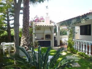 a house with a porch with a fireplace in the yard at Villa Cabanas in Tavira