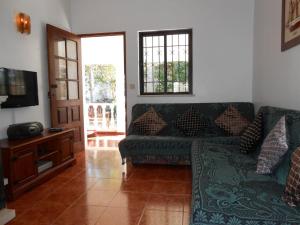 a living room with a couch and a television at Villa Cabanas in Tavira