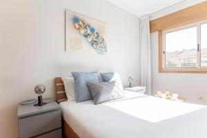 Un dormitorio blanco con una gran cama blanca y una ventana en Cozy Flat in Foz by LovelyStay, en Oporto