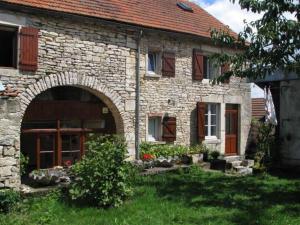 una casa de piedra con un arco en el patio en La Maison de Claire en Flavigny-sur-Ozerain