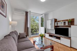 a living room with a couch and a tv at Apartment Riva in Makarska