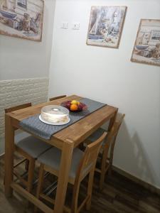 una mesa de madera con sillas y un plato de fruta. en Bed and breakfast Raggio di Sole en Iglesias