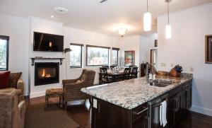 a kitchen with a fireplace and a living room at Alpenglow Penthouse by Revelstoke Vacations in Revelstoke