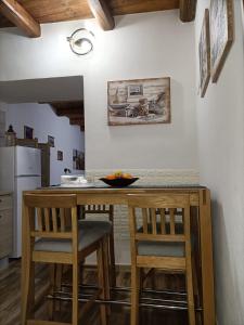 uma cozinha com um balcão com duas cadeiras e uma mesa em Bed and breakfast Raggio di Sole em Iglesias