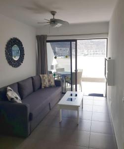 a living room with a couch and a table at Relax Arimar Apartment Puerto Rico in Puerto Rico de Gran Canaria