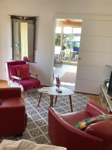 een woonkamer met rode stoelen en een tafel bij Charmant Appartement 2 pièces in Eccica-Suarella