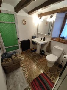 y baño con aseo blanco y lavamanos. en El Racó de la Civaderia, casa en Montblanc en Montblanc