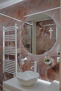 La salle de bains est pourvue d'un lavabo et d'un miroir. dans l'établissement Mark Hotel Tirana, à Tirana
