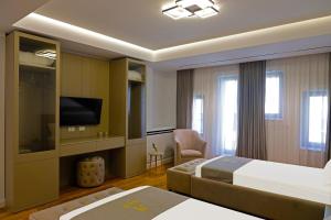 Habitación de hotel con cama y TV en Mark Hotel Tirana en Tirana