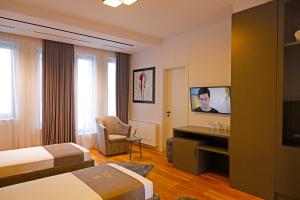 a hotel room with two beds and a flat screen tv at Mark Hotel Tirana in Tirana
