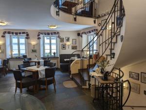 a restaurant with a spiral staircase and tables and chairs at Hotel Klapperburg in Beilstein