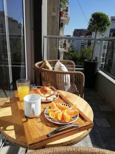 a table with a plate of oranges and a glass of orange juice at Studio Paraguay in Buenos Aires