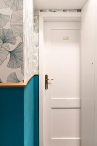 a white door in a room with a floral wallpaper at Lux Apartment II in Gdańsk