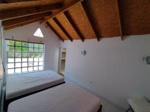 1 dormitorio con cama y ventana en Cabaña Karibeña, en Santa Marta