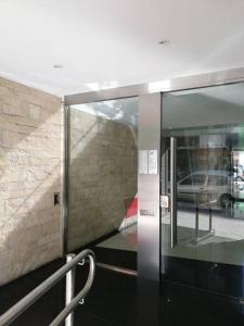 ブエノスアイレスにあるStudio Paraguayの通り付きの建物内のガラス張りのエレベータードア