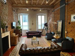 フィレンツェにあるVelvet Loft - Santo Spirito Apartmentのレンガの壁のリビングルーム(革製家具付)