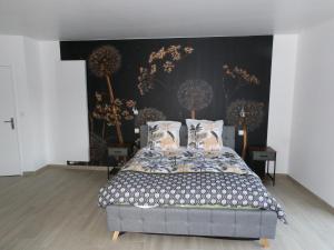 1 dormitorio con 1 cama y una pared con flores en La Ferme des Cerisiers, en Reventin-Vaugris