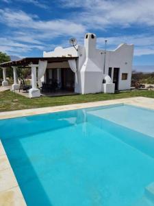 a blue swimming pool in front of a house at CASA CAFAYATE LA SOÑADA in Cafayate
