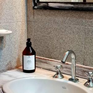a bottle of soap sitting on top of a bathroom sink at CASA CAFAYATE LA SOÑADA in Cafayate
