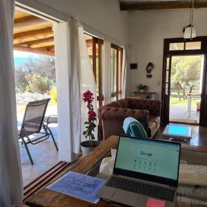 laptopa siedzącego na stole w salonie w obiekcie CASA CAFAYATE LA SOÑADA w mieście Cafayate