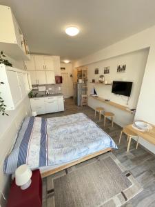 a bedroom with a large bed and a kitchen at Albert Apartman Balatonberény in Balatonberény