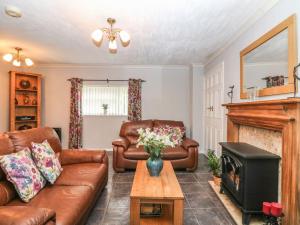 a living room with a couch and a fireplace at The Retreat in Liskeard