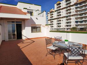 a patio with a table and chairs and some buildings at Duplex vista mar Peñiscola Playa Orangecosta in Peniscola