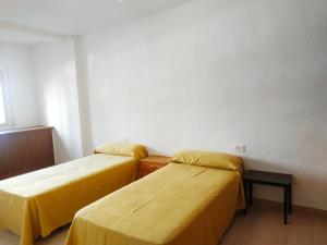 two beds in a room with yellow sheets at Duplex vista mar Peñiscola Playa Orangecosta in Peniscola