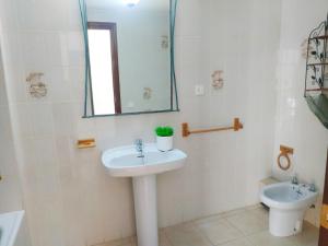 a bathroom with a sink and a toilet and a mirror at Duplex vista mar Peñiscola Playa Orangecosta in Peniscola +17 photos