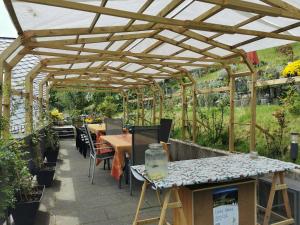 a patio with a wooden pergola and tables and chairs at Bed and Breakfast - Doppelzimmer in Sauerthal