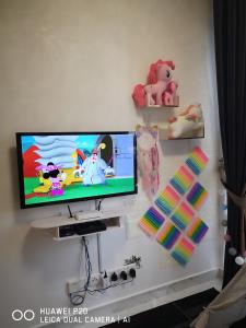 a flat screen tv hanging on a white wall at Prestige Troika Kota Bharu in Kota Bharu