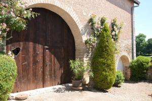 a large wooden door in a brick building at La ferme aux glycines in Aillevans +18 photos