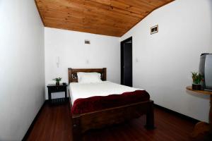 Tempat tidur dalam kamar di Hotel Aroma del Bosque Posada Cafe