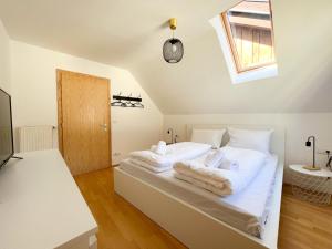- une chambre avec un lit doté de draps blancs et une fenêtre dans l'établissement Ferienwohnung im Zentrum von Kaltern, à Caldaro