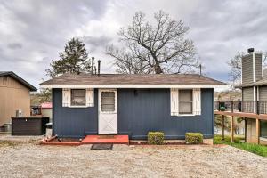 a small blue house with a white door at Quaint Table Rock Lake Hideout with Pool Access in Reeds Spring