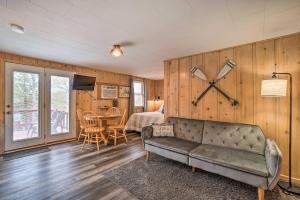 a living room with a couch and a clock on the wall at Quaint Table Rock Lake Hideout with Pool Access in Reeds Spring