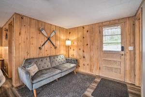 a living room with a couch and a clock on the wall at Quaint Table Rock Lake Hideout with Pool Access in Reeds Spring
