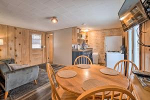a kitchen and dining room with a wooden table and chairs at Quaint Table Rock Lake Hideout with Pool Access in Reeds Spring