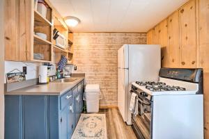 a kitchen with blue cabinets and a white refrigerator at Quaint Table Rock Lake Hideout with Pool Access in Reeds Spring