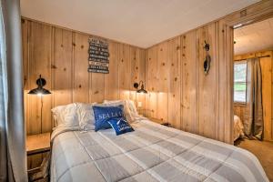 a bedroom with a bed in a room with wooden walls at Quaint Table Rock Lake Hideout with Pool Access in Reeds Spring