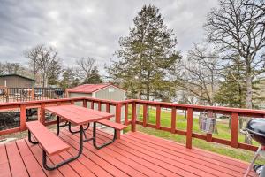a wooden deck with a picnic table and a grill at Quaint Table Rock Lake Hideout with Pool Access in Reeds Spring