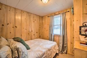 a bedroom with wooden walls and a bed in a room at Quaint Table Rock Lake Hideout with Pool Access in Reeds Spring