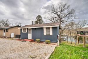 a blue house with a driveway in front of it at Quaint Table Rock Lake Hideout with Pool Access in Reeds Spring